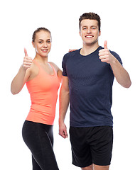 Image showing happy sportive man and woman showing thumbs up