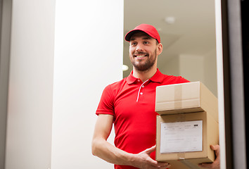 Image showing delivery man with parcel boxes at customer door