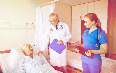 Image showing doctor and nurse visiting senior woman at hospital