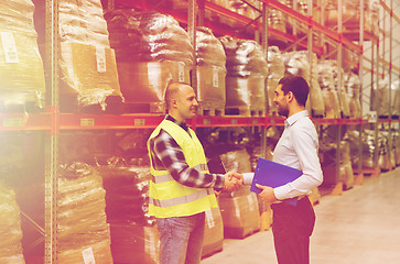 Image showing worker and businessmen with clipboard at warehouse