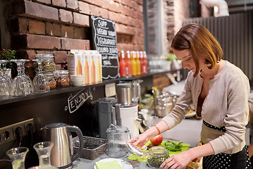 Image showing happy woman or barmaid cooking at vegan cafe