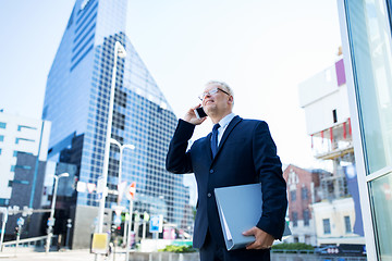 Image showing senior businessman calling on smartphone in city