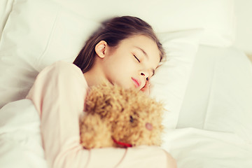 Image showing girl sleeping with teddy bear toy in bed at home