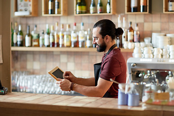 Image showing happy man or waiter with chalkboard banner at bar