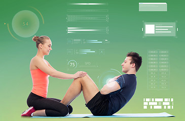 Image showing happy sportive man and woman doing sit-ups