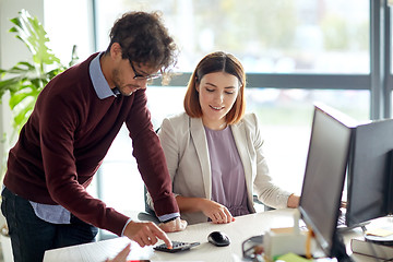 Image showing happy business team with calculator at office