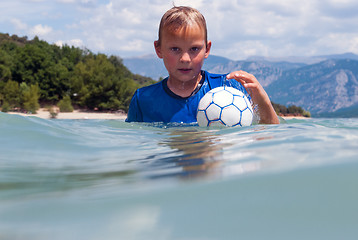 Image showing Boy with UV protection shirt in a lake