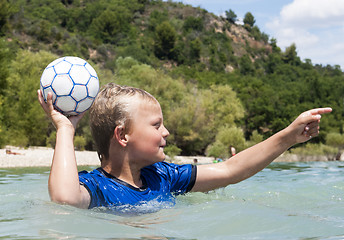 Image showing Boy playing in a lake with a ball