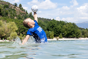 Image showing Boy catching a ball in a lake