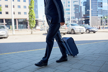 Image showing senior businessman walking with travel bag in city