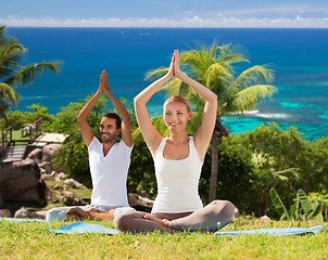 Image showing smiling couple making yoga exercises outdoors