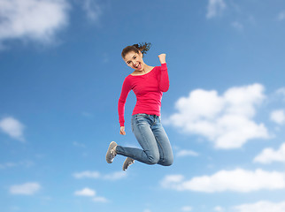 Image showing smiling young woman jumping in air