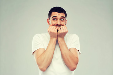 Image showing scared man in white t-shirt over gray background