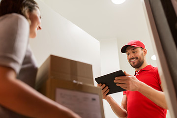 Image showing deliveryman with tablet pc and customer with boxes