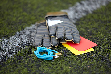 Image showing gloves, whistle and caution cards on soccer field