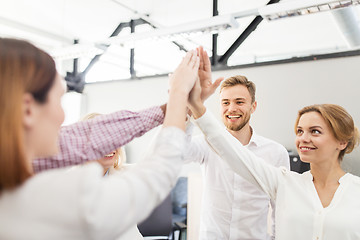 Image showing happy business team making high five at office