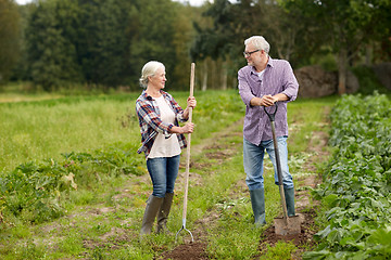 Image showing senior couple with shovels at garden or farm