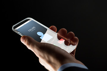 Image showing close up of hand with incoming call on smartphone
