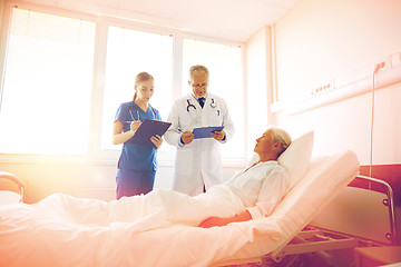 Image showing doctor and nurse visiting senior woman at hospital