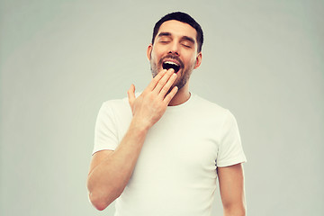 Image showing yawning man over gray background