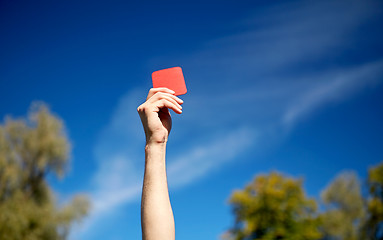 Image showing referee hands with red card on football field