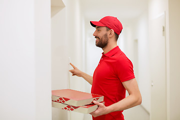 Image showing delivery man with pizza boxes ringing doorbell