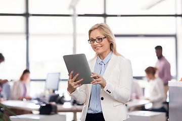 Image showing smiling businesswoman with tablet pc at office