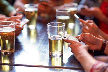 Image showing friends with beer and smartphones at bar or pub