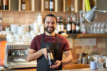 Image showing happy man or waiter with bottle of red wine at bar