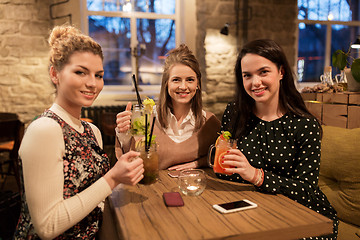 Image showing happy friends with drinks at restaurant