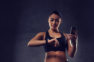 Image showing woman with heart-rate watch and smartphone in gym