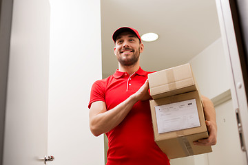 Image showing delivery man with parcel boxes at customer door