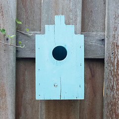 Image showing Blue birdhouse on a wooden fence