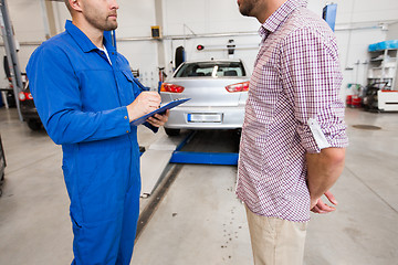 Image showing auto mechanic with clipboard and man at car shop