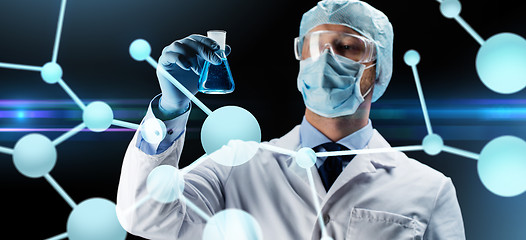Image showing scientist in mask holding flask with chemical