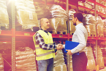 Image showing worker and businessmen with clipboard at warehouse