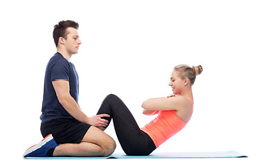 Image showing happy sportive man and woman doing sit-ups