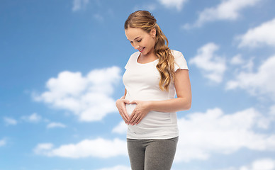 Image showing happy pregnant woman showing heart gesture