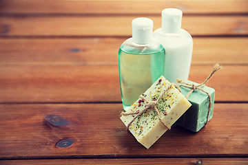 Image showing close up of handmade soap bars and lotions on wood