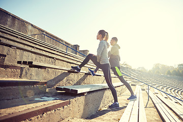 Image showing couple stretching leg on stands of stadium