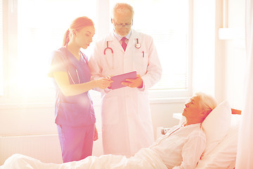 Image showing doctor and nurse visiting senior woman at hospital