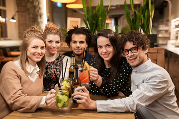 Image showing happy friends with drinks at bar or cafe