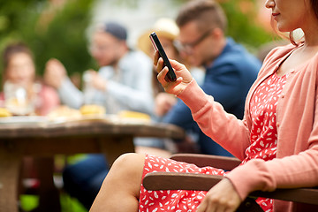 Image showing woman with smartphone and friends at summer party