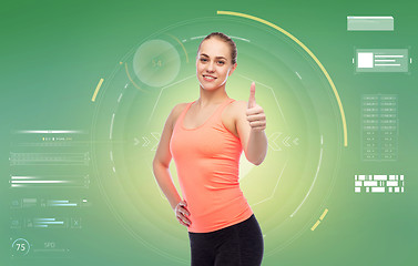 Image showing happy sportive young woman showing thumbs up