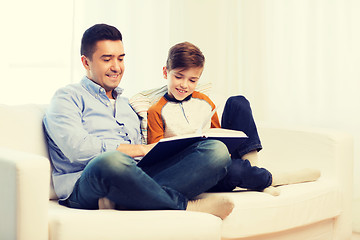 Image showing happy father and son reading book at home