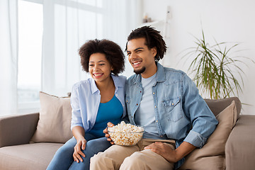 Image showing smiling couple with popcorn watching tv at home