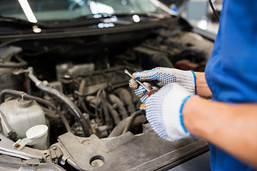 Image showing mechanic man with wrench repairing car at workshop