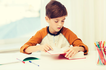 Image showing student boy reading book or textbook at home