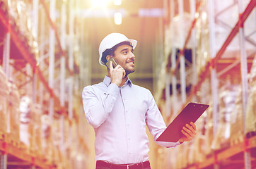 Image showing man with clipboard and smartphone at warehouse