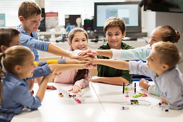 Image showing happy children holding hands at robotics school